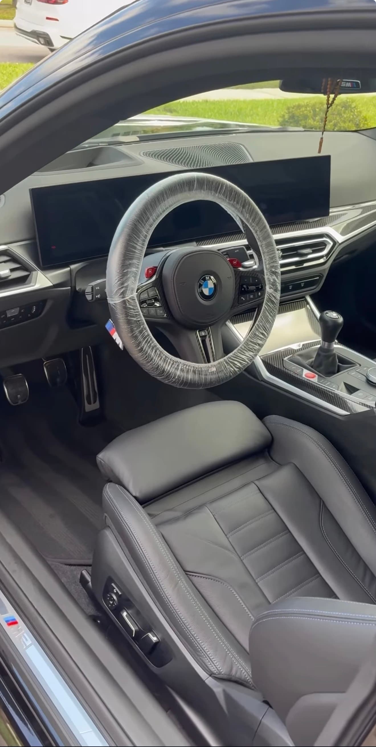 Clean BMW interior with protected steering wheel and freshly detailed surfaces