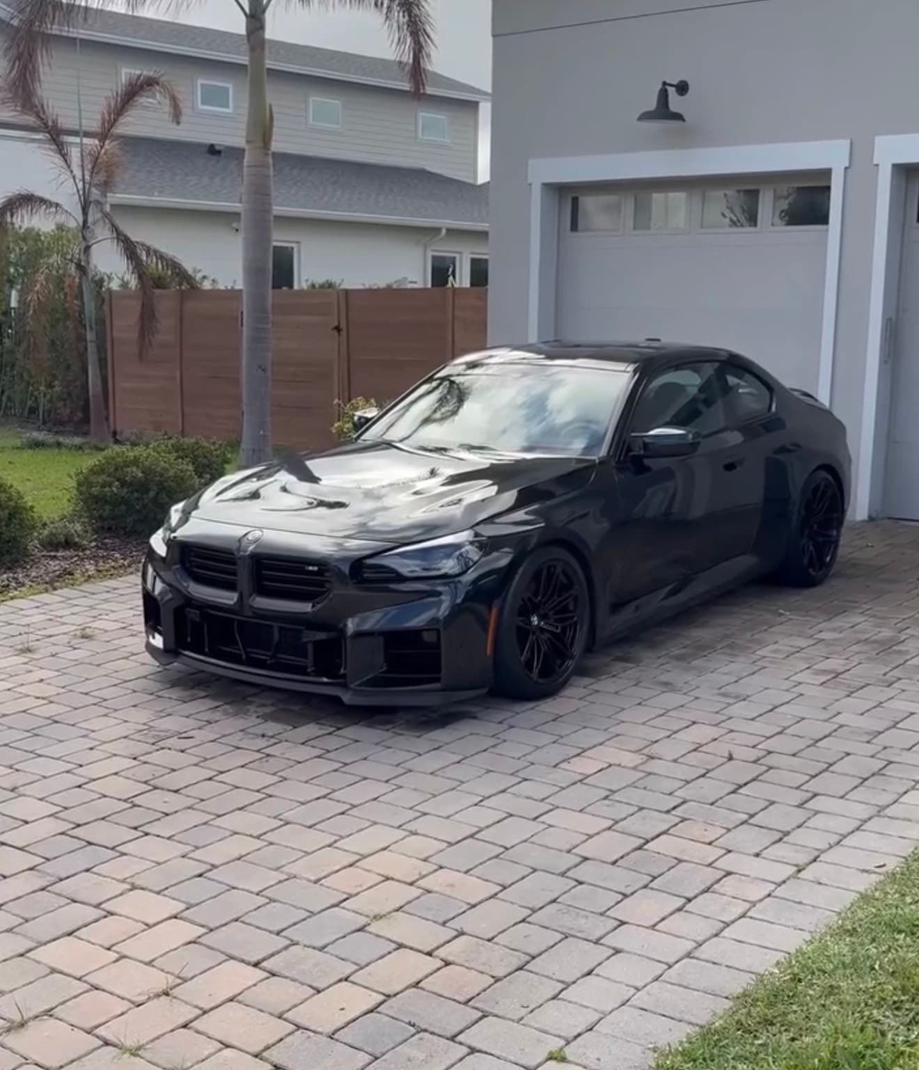 Black BMW coupe detailed on a residential driveway in Orlando